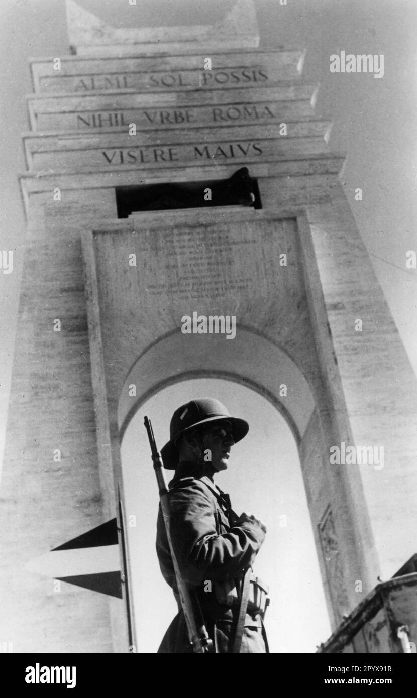 A soldier of the German Afrika Korps stands at his post in front of the monument of Fascist Reconstruction (Arae Philaenorum) on the Via Balbia coastal road between Ras Lanuf and El Agheila in present-day Libya. Photo: Boecker [automated translation] Stock Photo