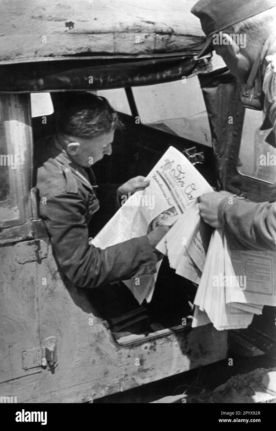 'A soldier of the German Afrika Korps reads the front newspaper '' Die Oase'' in a car. [automated translation]' Stock Photo