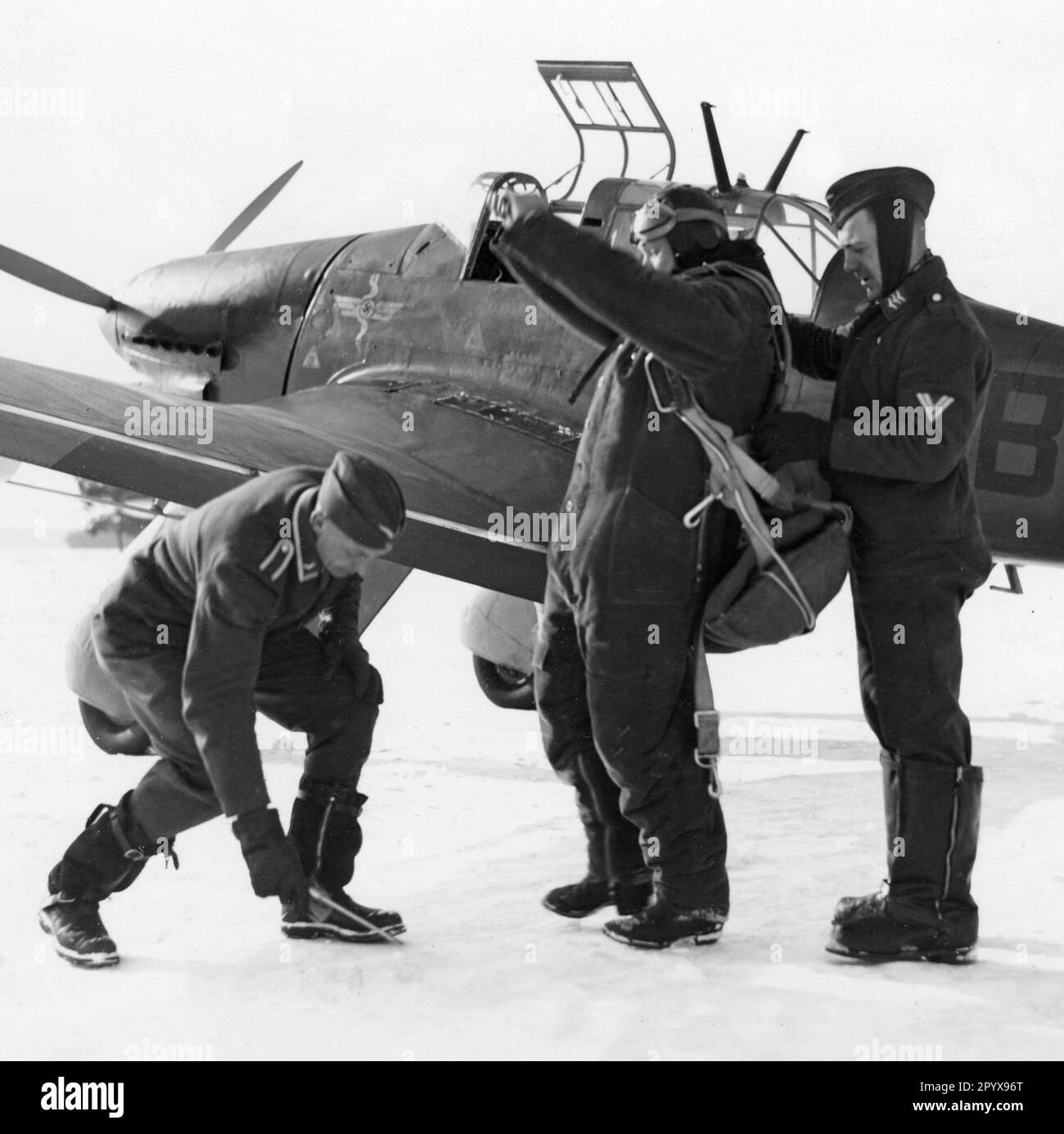 'The pilot of a Junkers Ju 87 ''Stuka'' is ''dressed'' before take-off and helped to attach the parachute. [automated translation]' Stock Photo