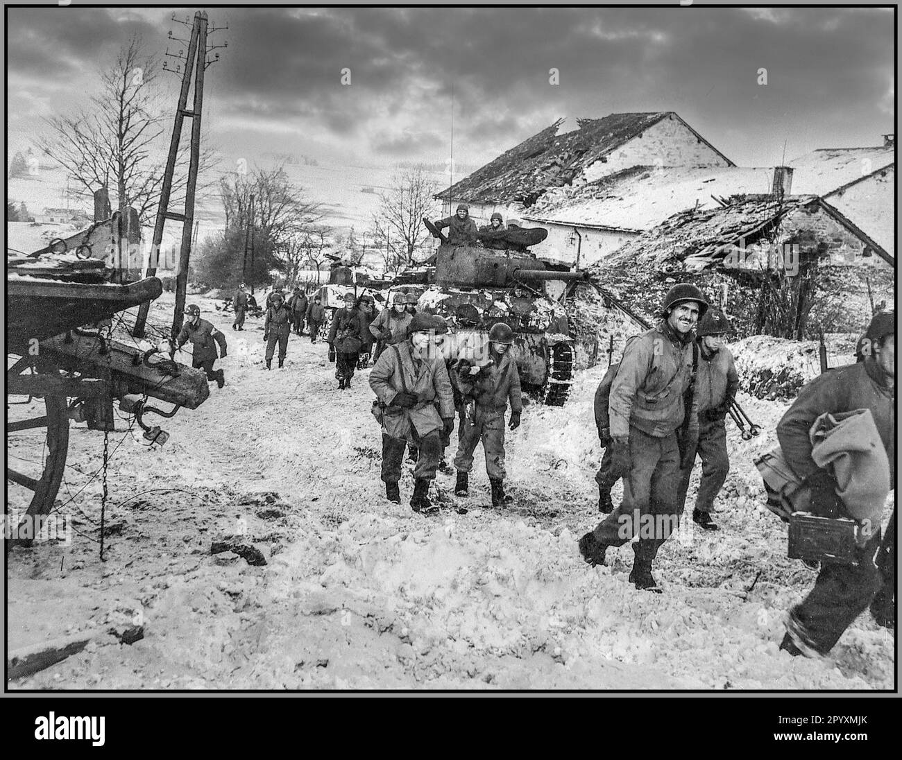 BATTLE OF THE BULGE WW2 American soldiers slog through the mud and snow during the Battle of the Bulge in December 1944. It was the coldest winter in 50 years in Europe and developed into the biggest battle with Nazi Germany Occupation on the Western Front during World War II. Stock Photo