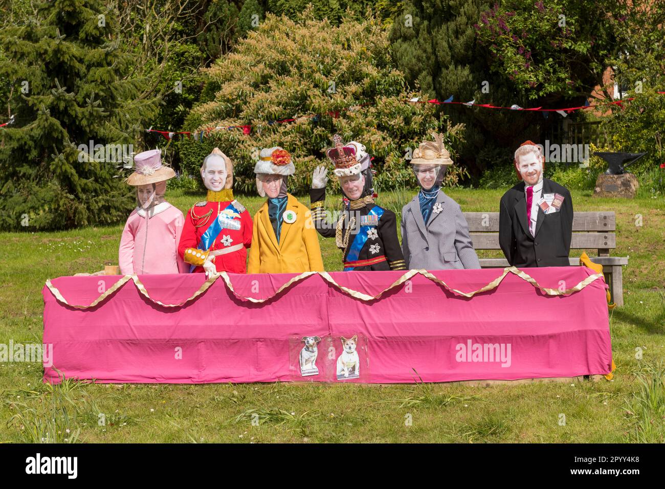 To celebrate the coronation of King Charles III, in Sheriffhales, Shropshire, UK, the village has prepared a mockup of the famous Buckingham Palace balcony complete with life-size models of the royal family, but without Meghan. Harry is shown with his passport and first-class boarding cards. Stock Photo