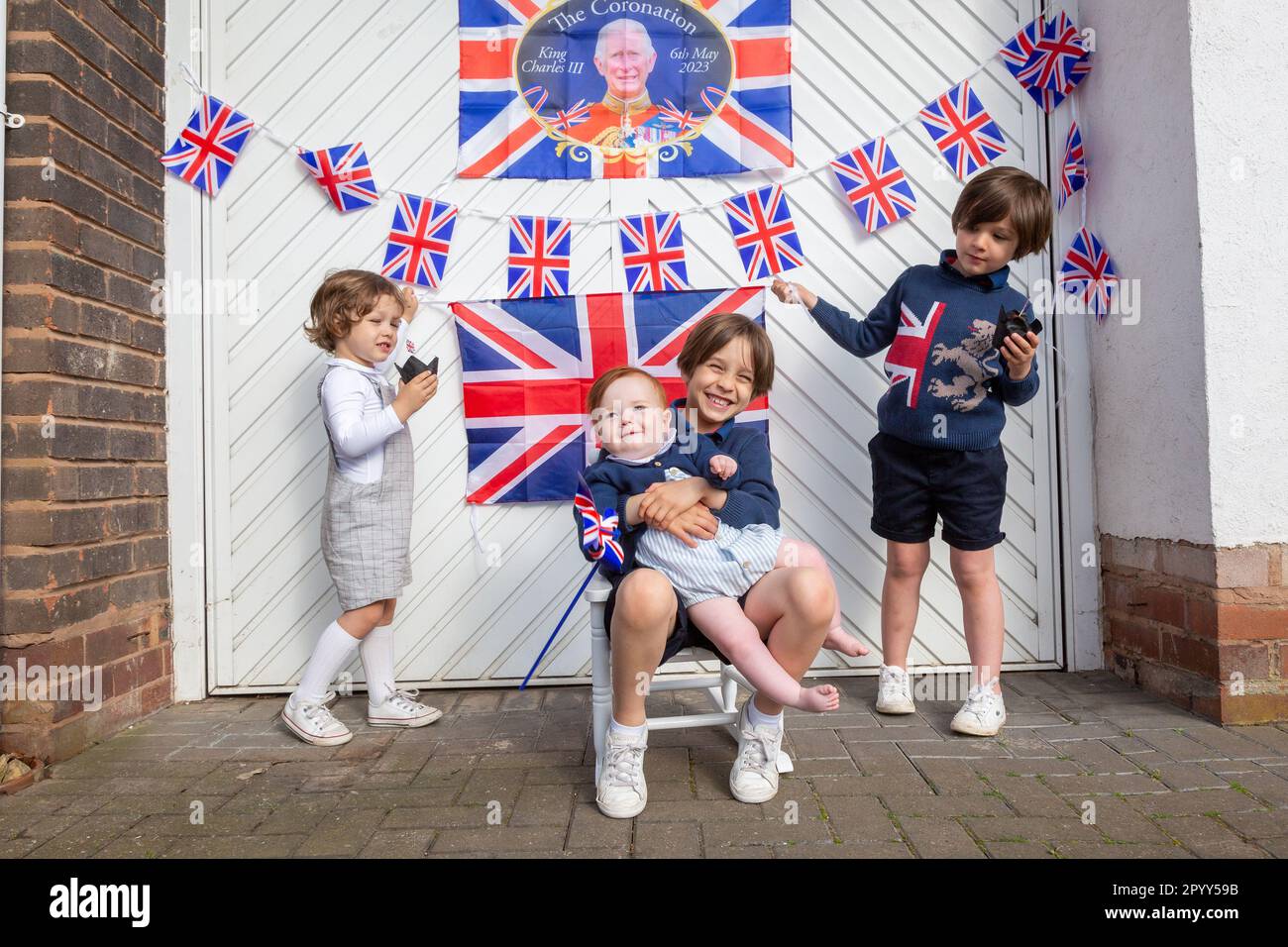 Halesowen, West Midlands, UK. 5th May, 2023. Four young excited brothers outside their family's