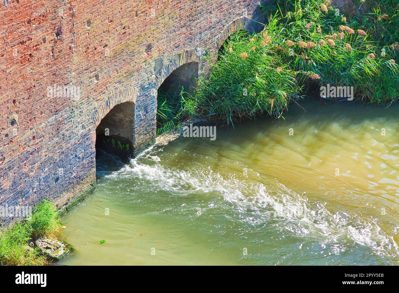 Dangerous toxic polluted water running towards the river. Stock Photo