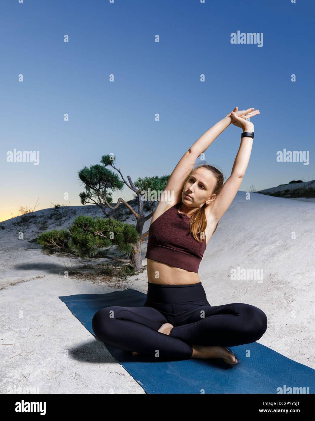 Young woman doing yoga stretching outdoors in the evening Stock Photo