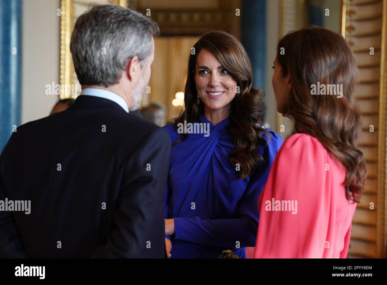 The Princess of Wales speaks (centre) talks with Mary, Crown Princess of Denmark and Crown Prince Frederik of Denmark, during a reception at Buckingham Palace, in London, for overseas guests attending the coronation of King Charles III.. Picture date: Friday May 5, 2023. Stock Photo