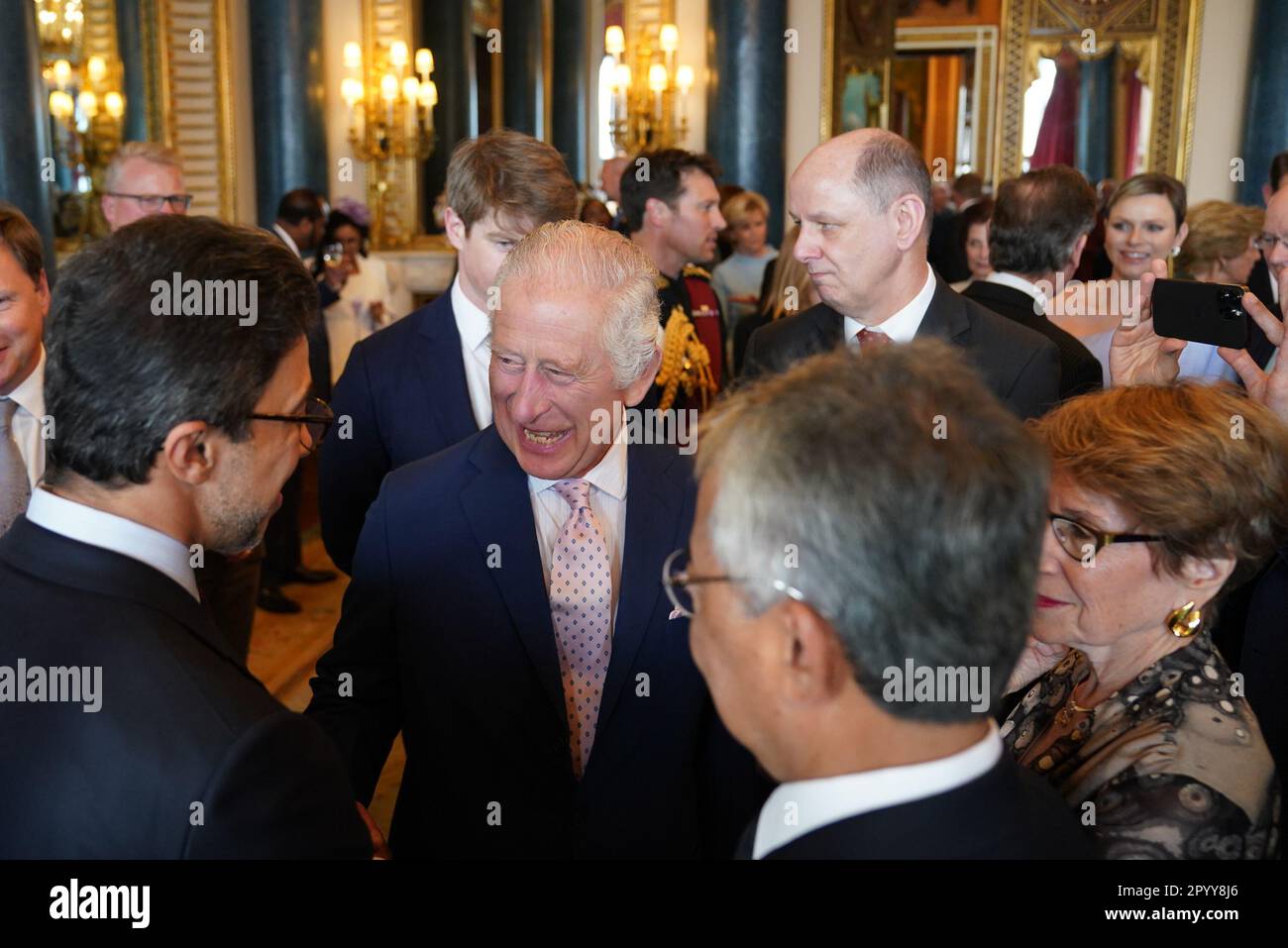 King Charles III (centre) speaks to guests during a reception at Buckingham Palace, in London, for overseas guests attending his coronation. Picture date: Friday May 5, 2023. Stock Photo