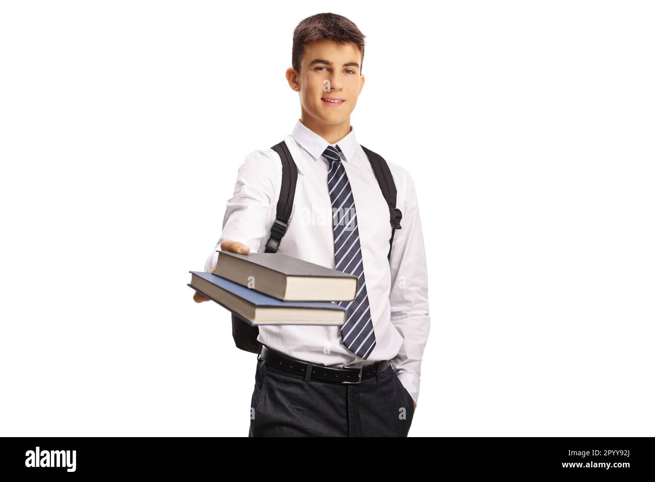 Male teenage student in a school uniform giving books isolated on white background Stock Photo