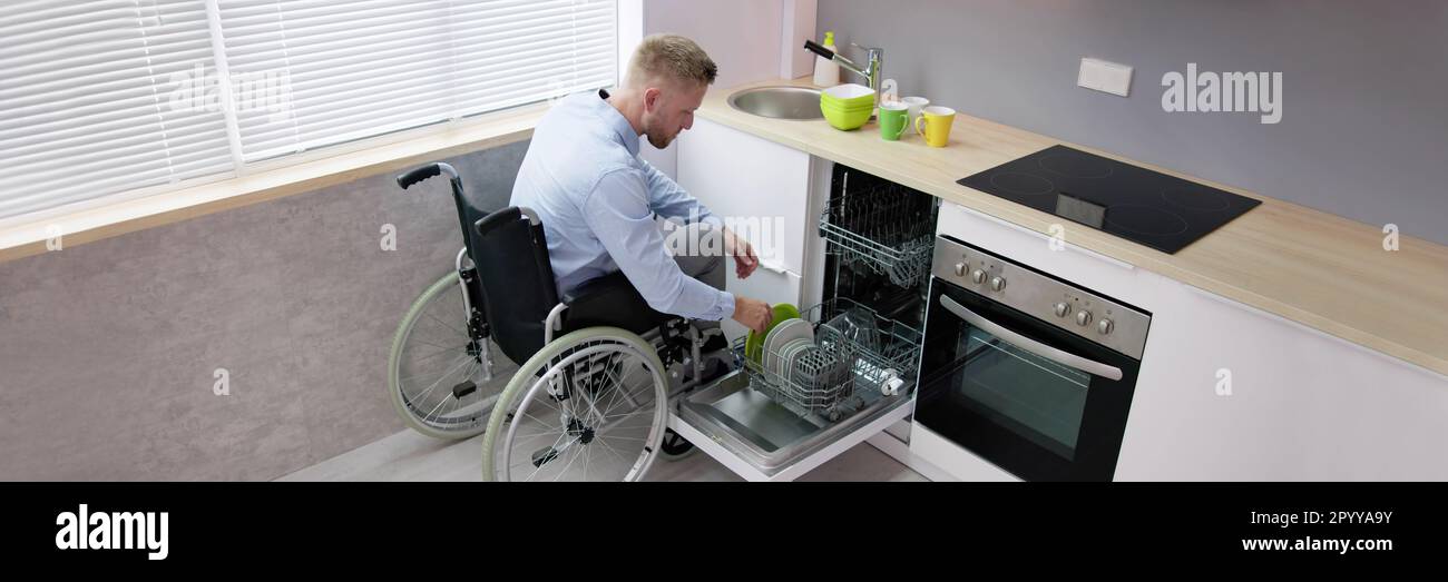 Person With Disability In Wheelchair Using Dishwasher In Kitchen Stock Photo Alamy