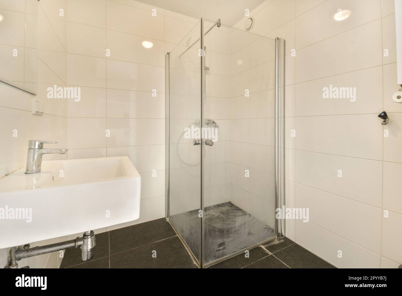 a modern bathroom with white tile walls and black tiles on the floor ...