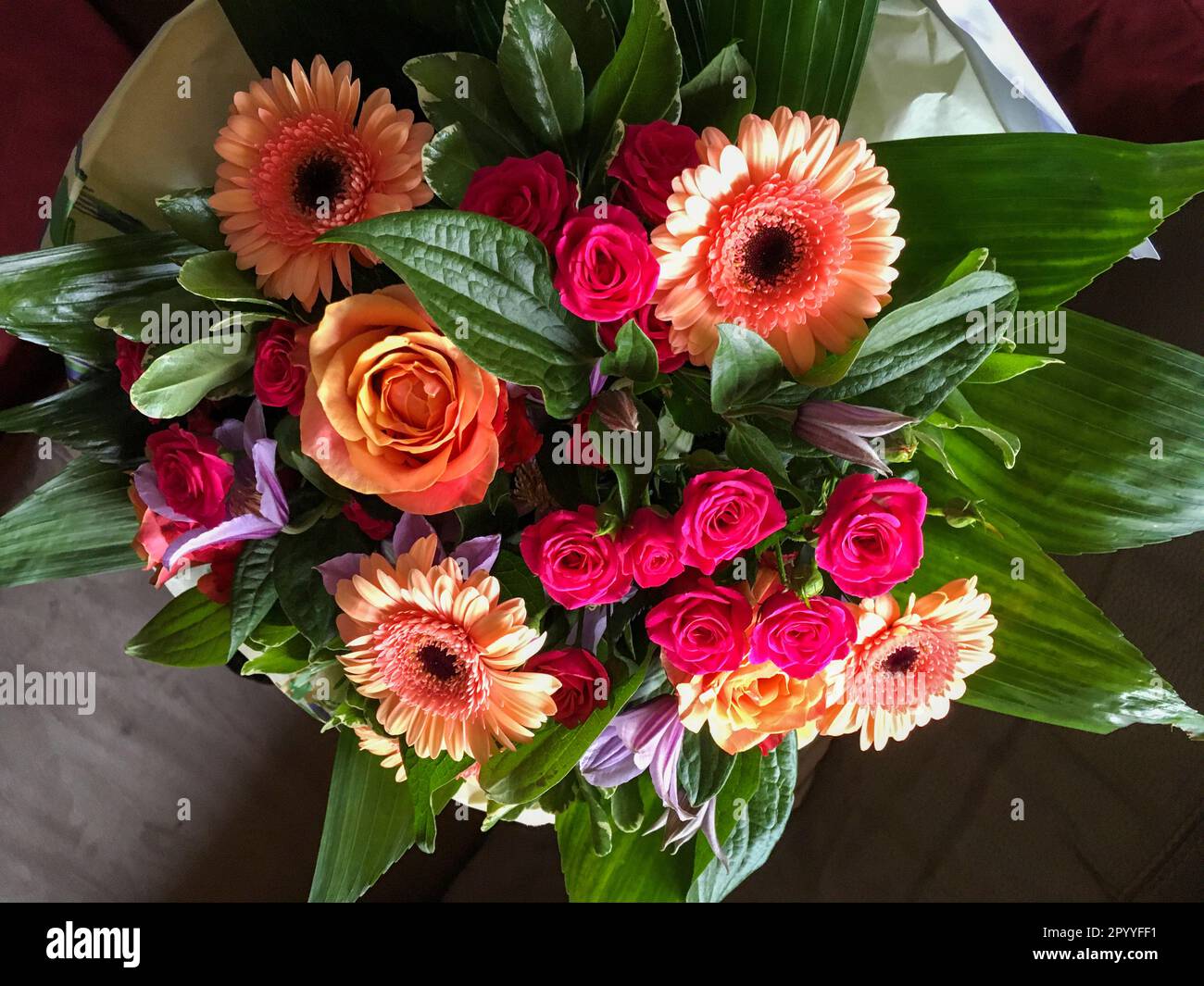 Bunter Blumenstrauß mit Gerbera, Rosen und grünen Blättern Stock Photo