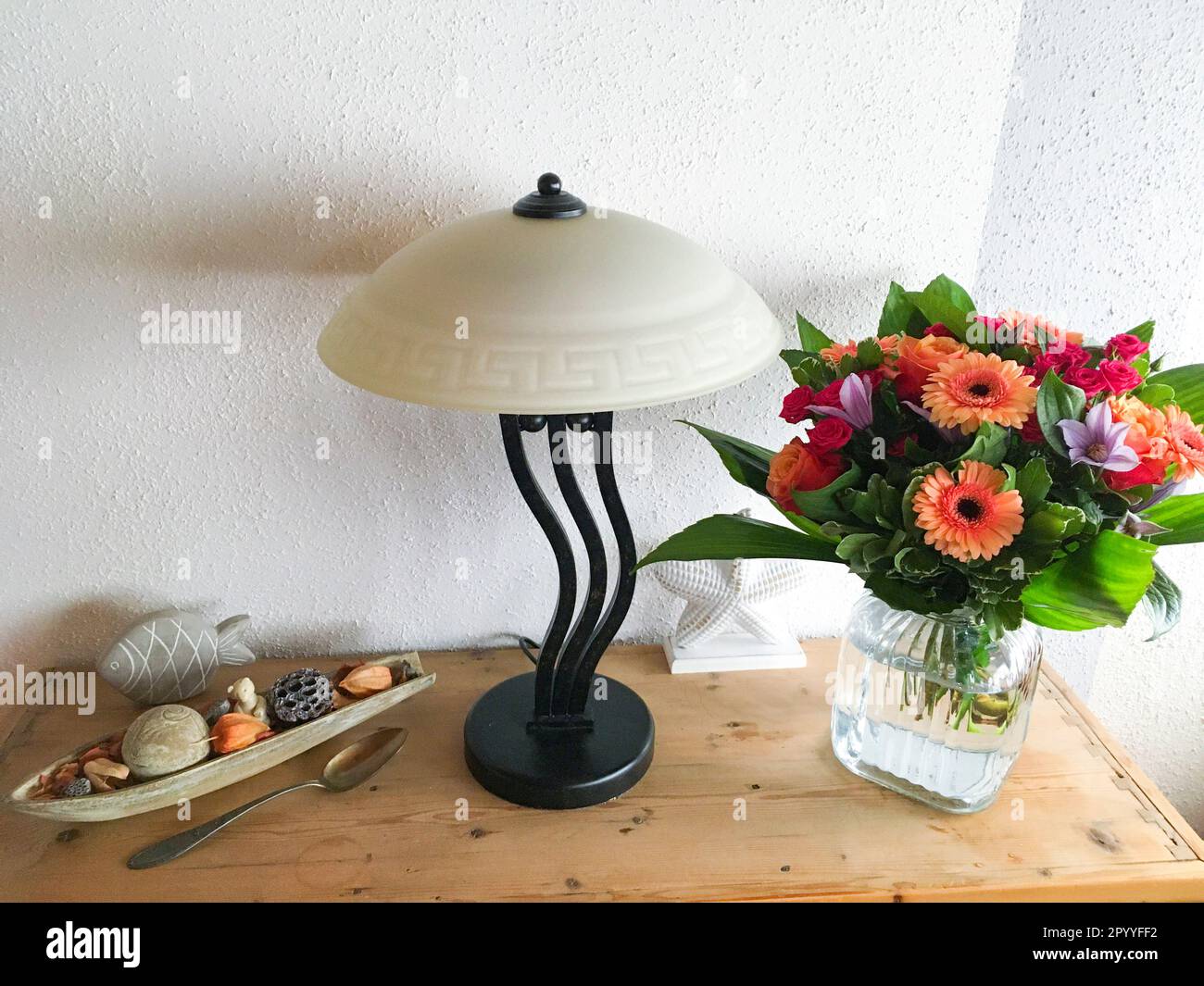 Bunter Blumenstrauß mit Gerbera, und Rosen auf einer Kommode Stock Photo