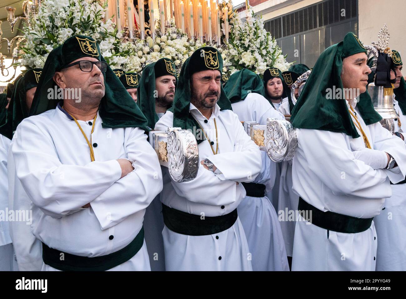 A Nazareno weeps as he prepares for his sacred duty of carrying a massive platform with a statue of Jesus Christ and the Romans in a procession during Holy Week or Semana Santa, April 5, 2023 in Ronda, Spain. Ronda, first settled in the 6th century B.C. has been holding Holy Week processions for over 500-years. Stock Photo