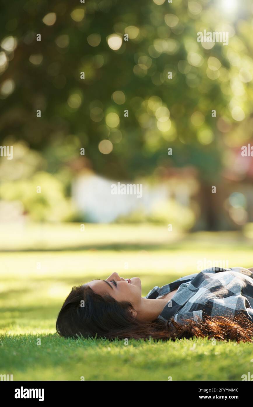 Relaxing i. Young woman lying on her back on the grass in a park Stock ...