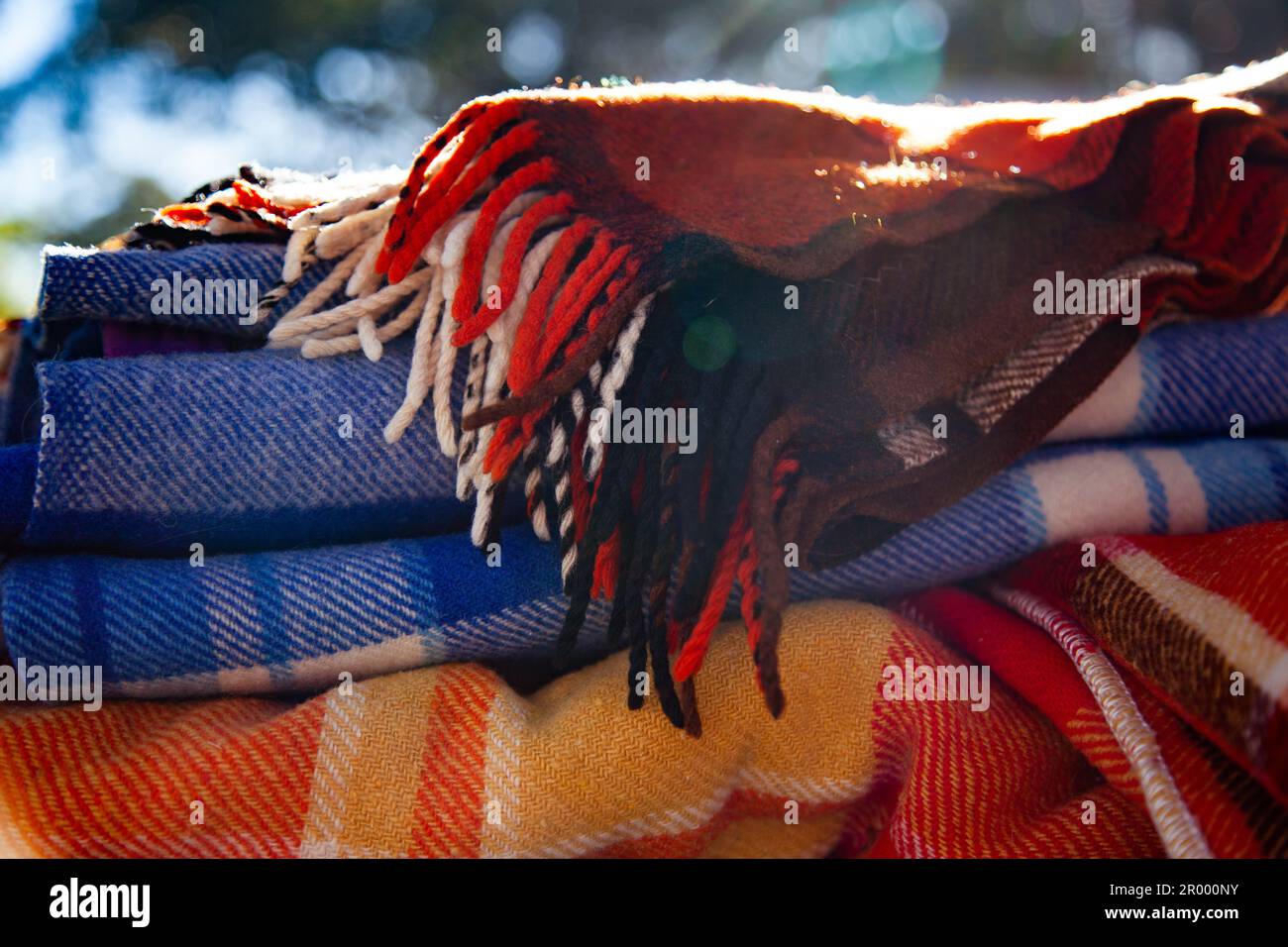 Light flare over woollen blankets piled outside in winter for camping around campfire Stock Photo
