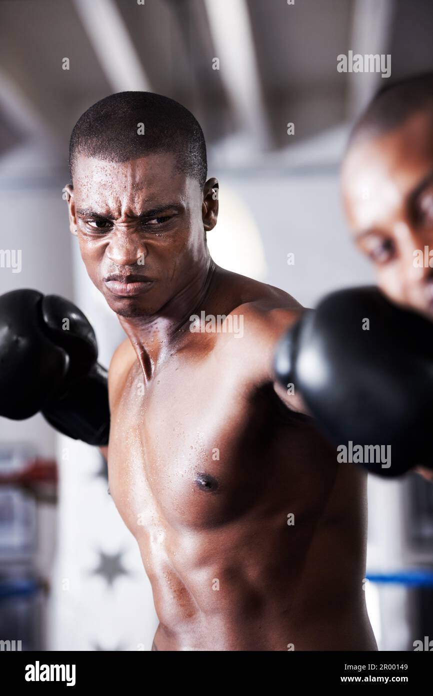 Knockout punch. An african american boxer delivering a knockout punch