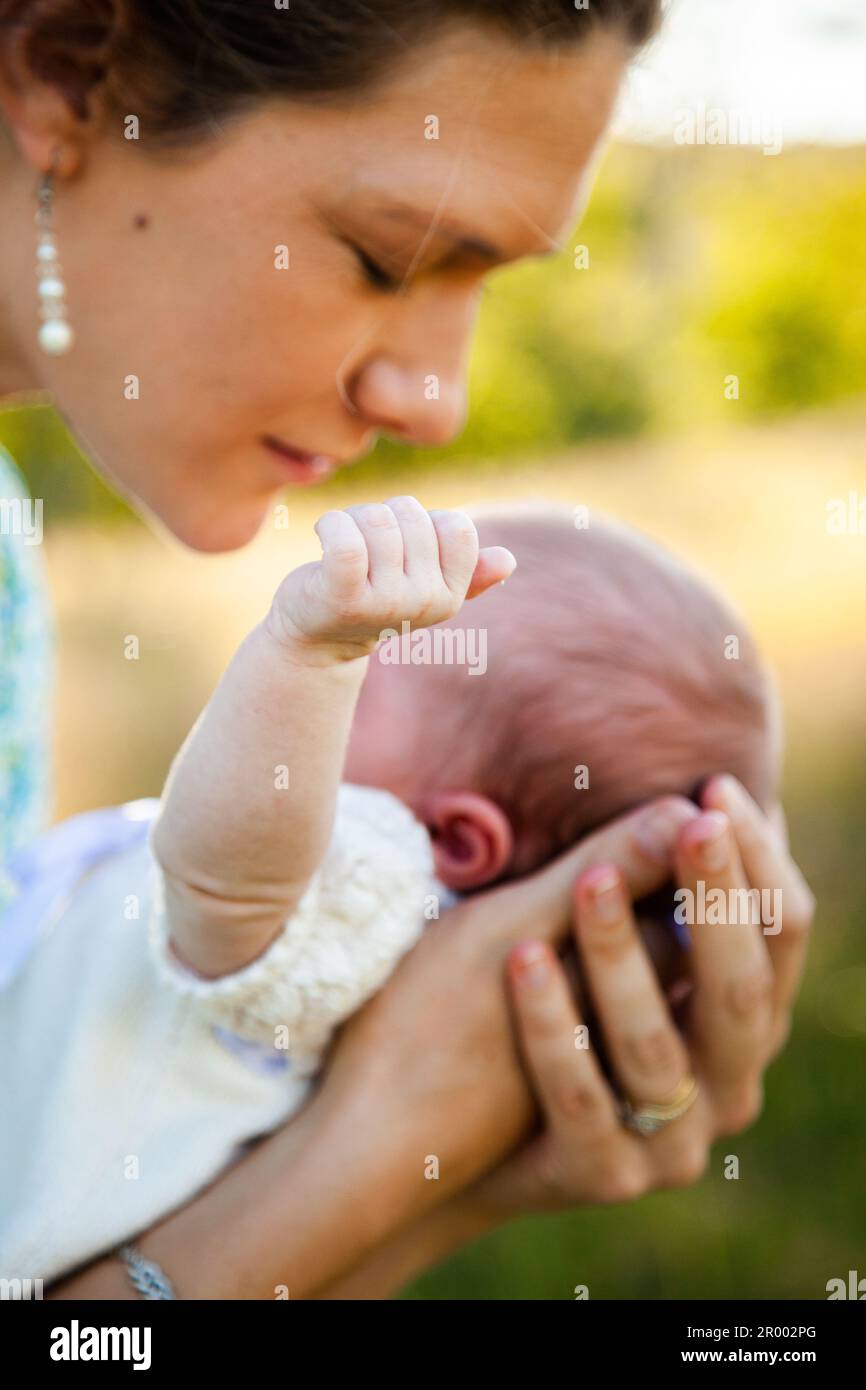 mother bending over newborn baby with arm reaching out Stock Photo Alamy