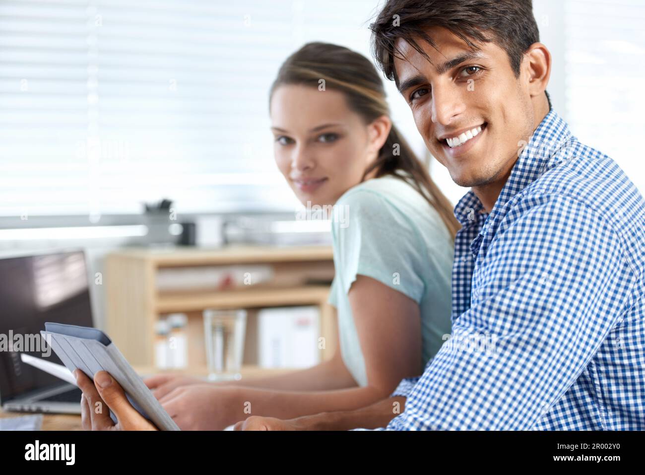 Weve got this. two colleagues working in the office. Stock Photo