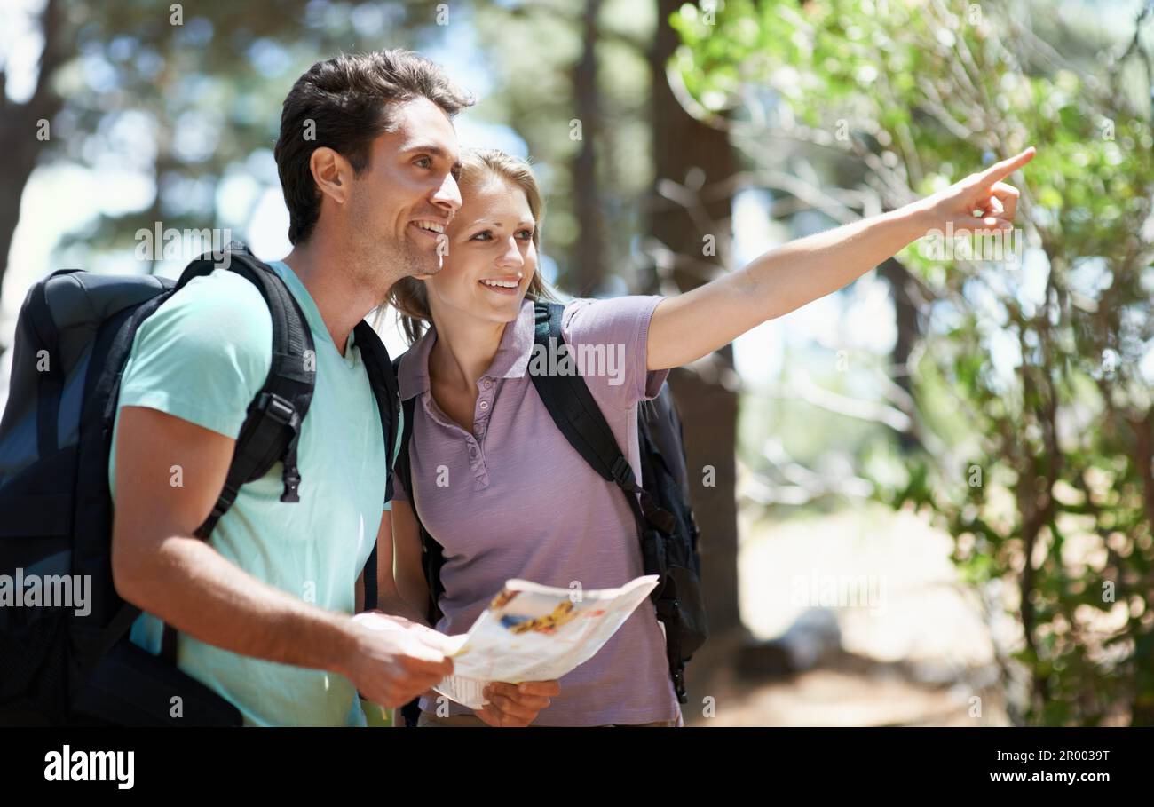 Lets explore that trail. A happy young couple backpacking through the ...
