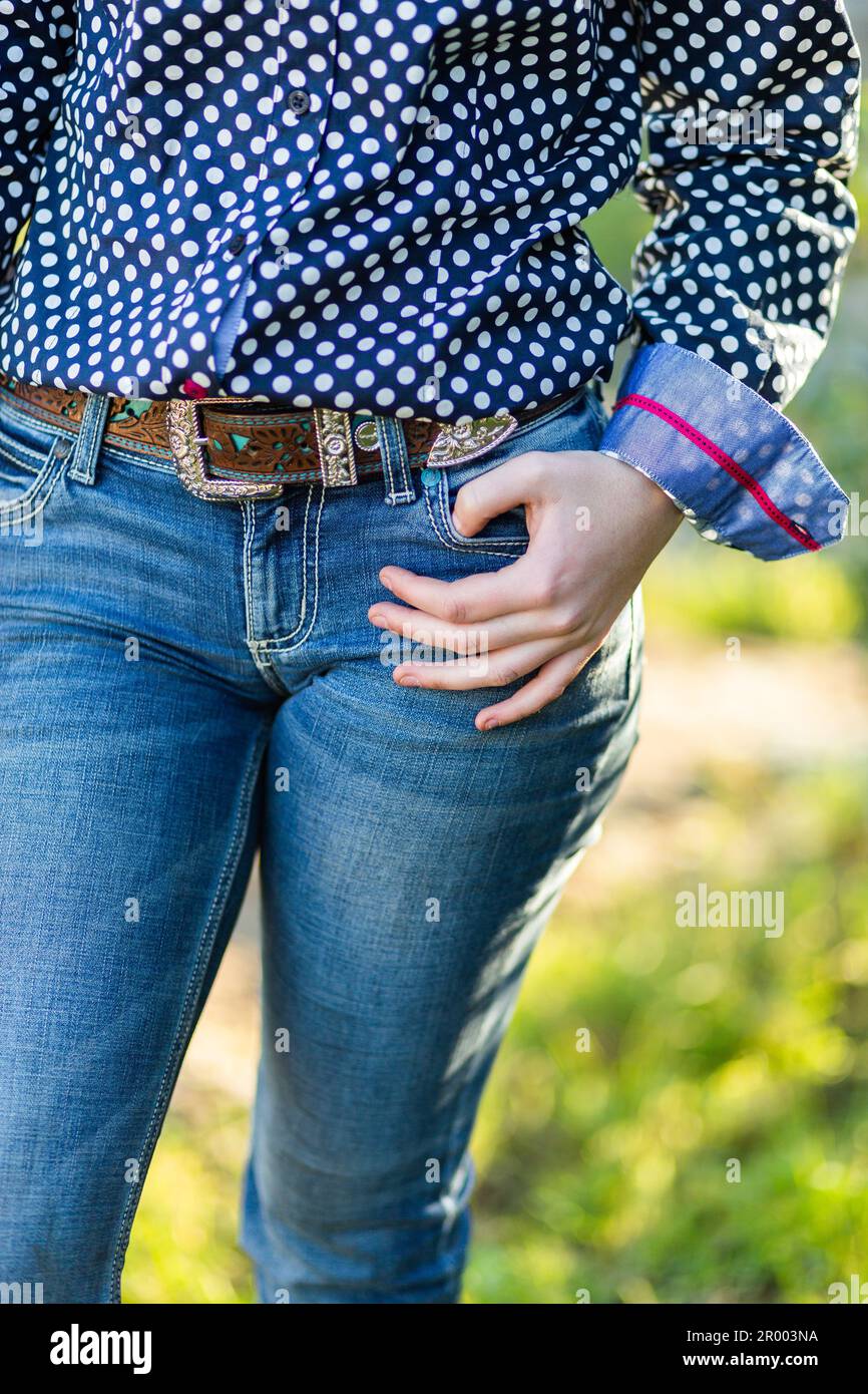 Young country woman with her hand on her hip with belt and jeans Stock Photo