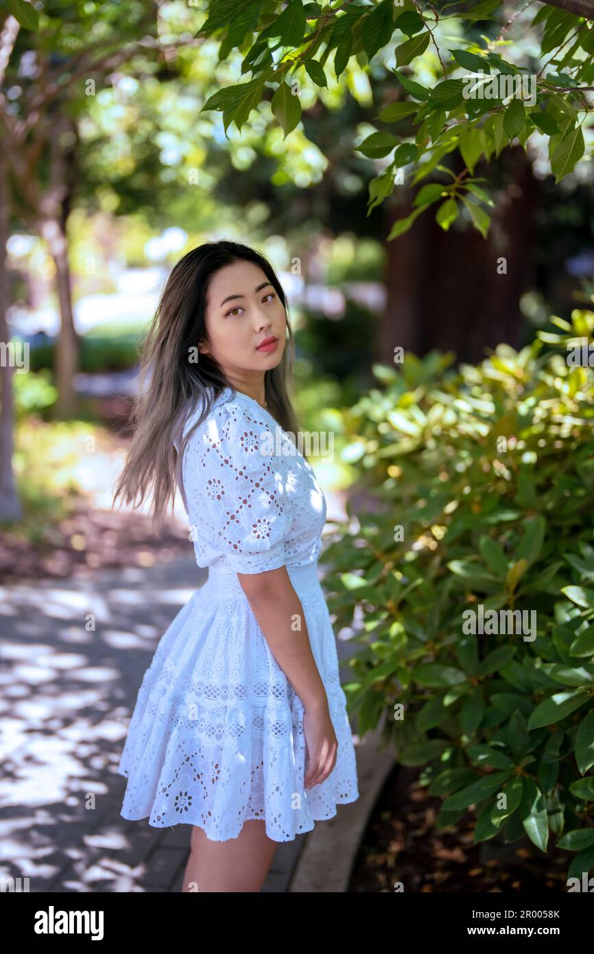 Young Asian American Woman Standing in a Shady Garden Pathway Stock Photo