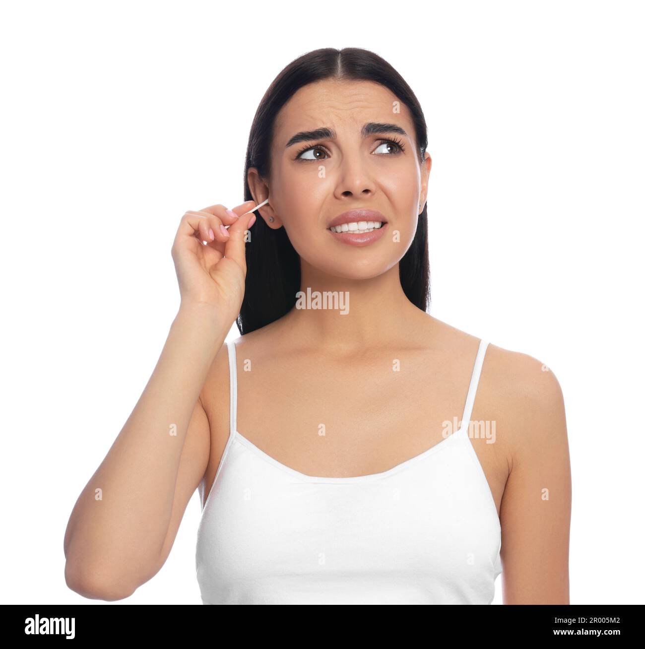 Young woman cleaning ear with cotton swab on white background Stock