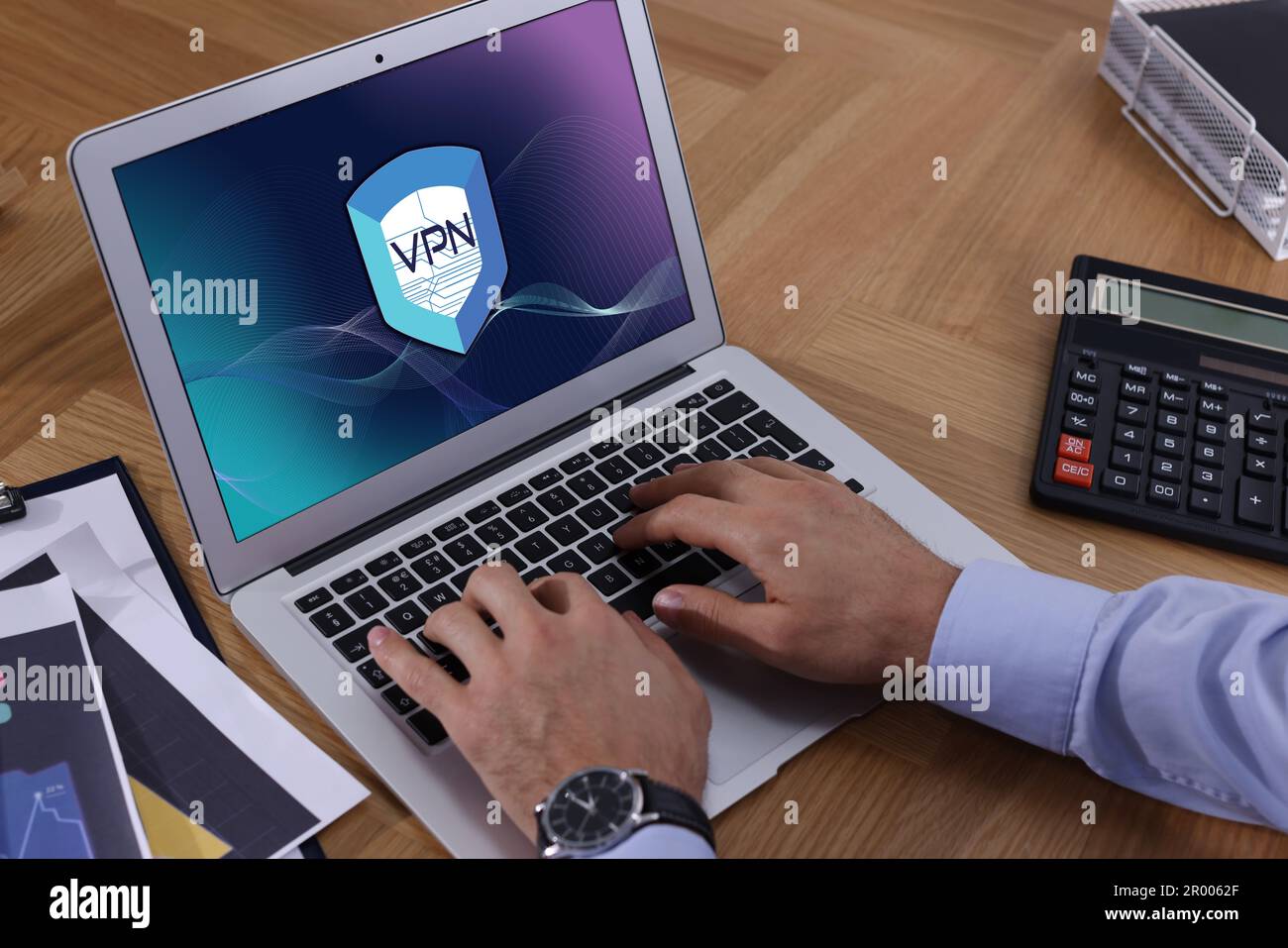 Man using laptop with switched on VPN at table, closeup Stock Photo
