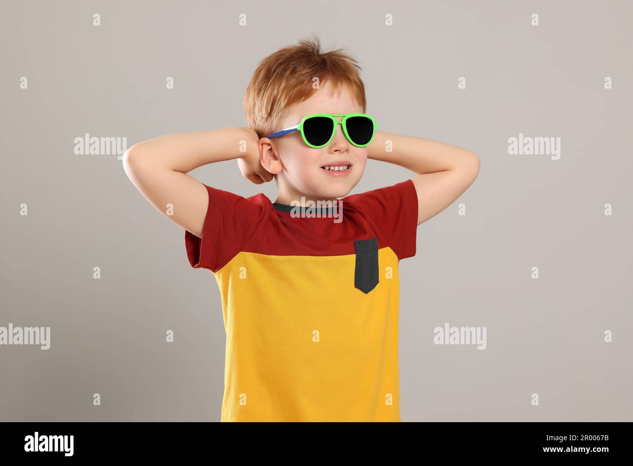 Cute little boy with sunglasses on light grey background Stock Photo