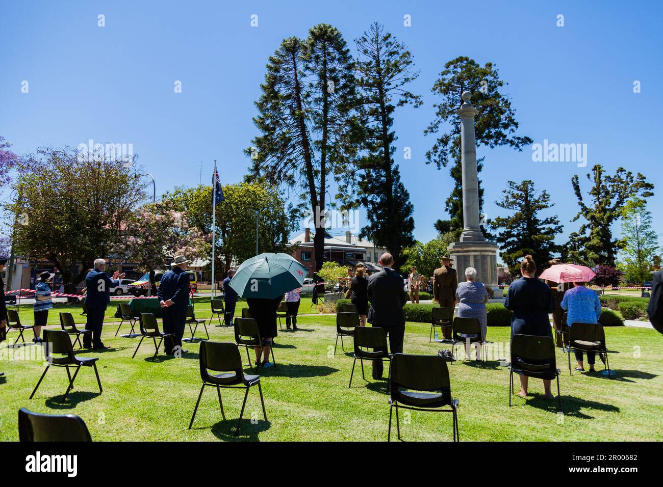 Social distanced seating during public event remembrance day ceremony during the 2020 covid-19 pandemic with view of cenotaph in Burdekin Park Stock Photo
