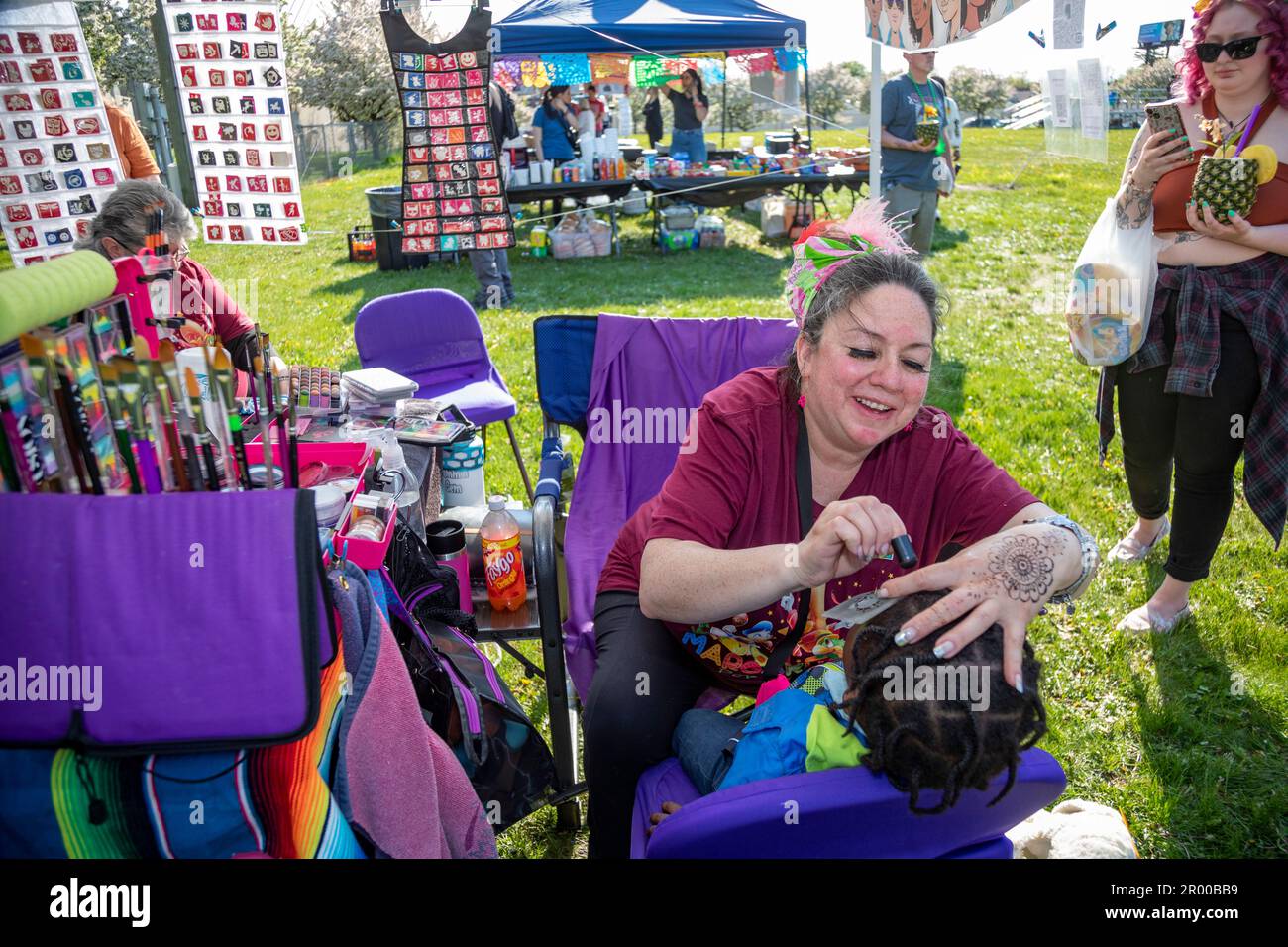 Detroit, Michigan, USA. 5th May, 2023. An artist does face painting for a child during the celebration of the Cinco de Mayo holiday in the Mexican-American community. Credit: Jim West/Alamy Live News Stock Photo