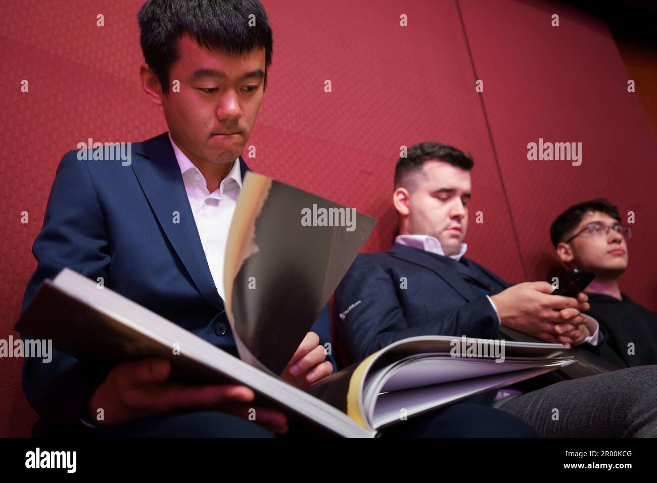 Bucharest, Romania. 5th May, 2023: Ding Liren, Chinese chess grandmaster and the reigning world chess champion, looks in the photo album 'Wild Romania' during the press conference held by Garry Kasparov (not in Picture), former Russian chess grandmaster, the best chess player of all time, in the opening ceremony of the Superbet Chess Classic Romania 2023, the first stage of the Grand Chess Tour 2023 circuit, held in Bucharest on on May 5th, 2023. During the 10 days of the tournament, May 5-15, Ding Liren will compete against nine other top rated FIDE players. Credit: Lucian Alecu/Alamy Live Ne Stock Photo
