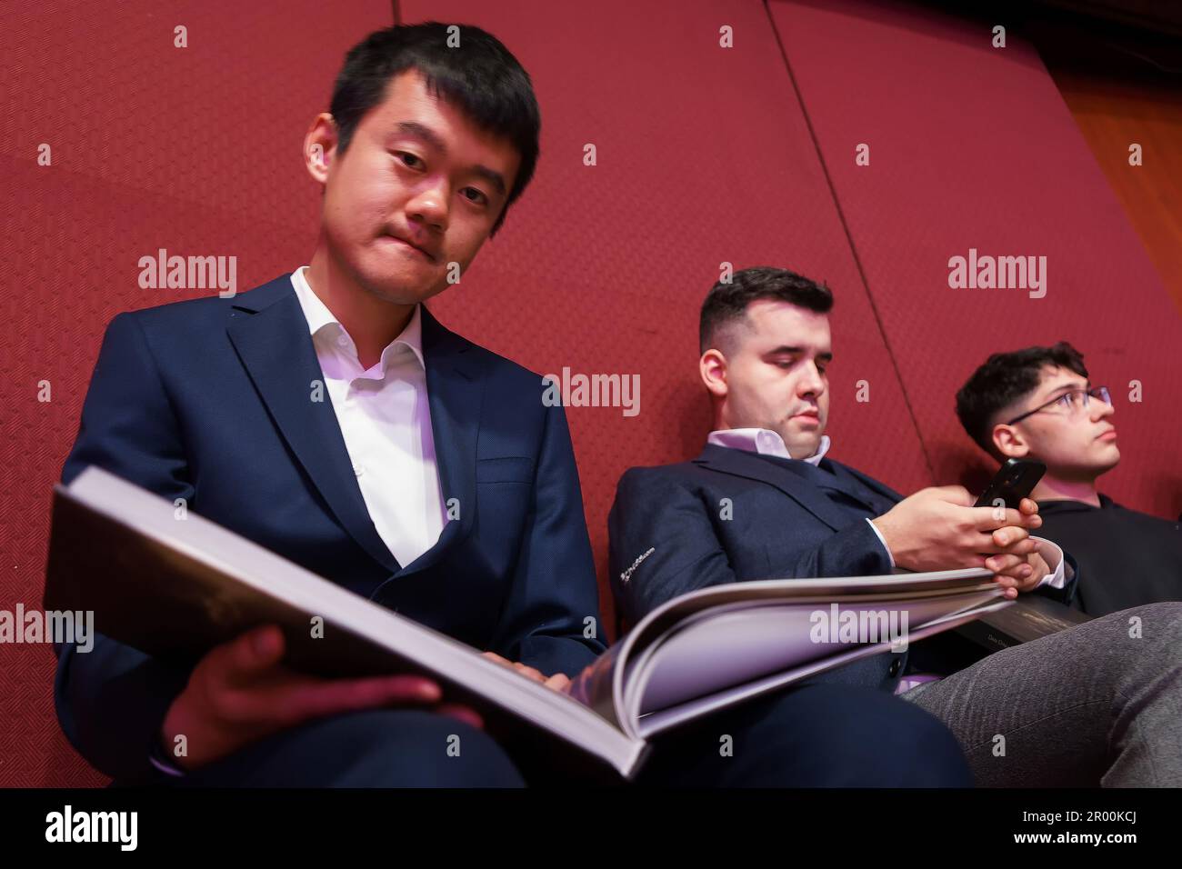 Bucharest, Romania. 5th May, 2023: Ding Liren, Chinese chess grandmaster and the reigning world chess champion, looks in the photo album 'Wild Romania' during the press conference held by Garry Kasparov (not in Picture), former Russian chess grandmaster, the best chess player of all time, in the opening ceremony of the Superbet Chess Classic Romania 2023, the first stage of the Grand Chess Tour 2023 circuit, held in Bucharest on on May 5th, 2023. During the 10 days of the tournament, May 5-15, Ding Liren will compete against nine other top rated FIDE players. Credit: Lucian Alecu/Alamy Live Ne Stock Photo