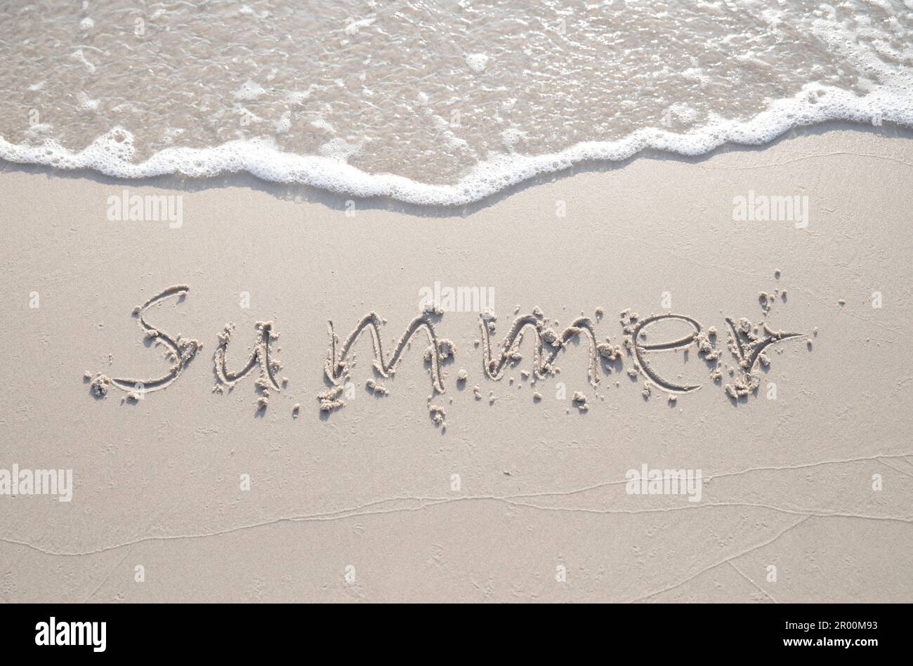 Word 'Summer' hand written in the sand. Close up sand texture on beach in summer. Vacation, holiday concept, Stock Photo