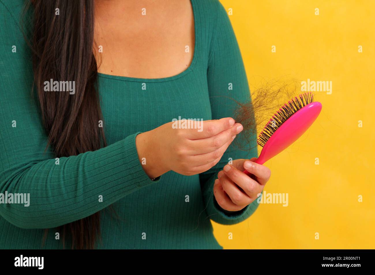 Woman's hands take a hairbrush with many fallen hairs after brushing