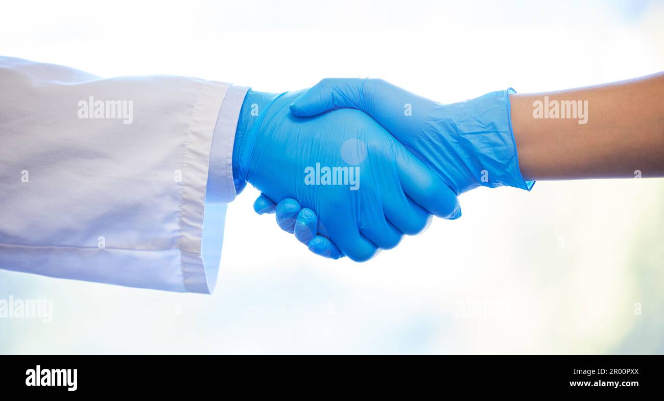 Partners in dental practice. two unrecognisable dentists wearing gloves and shaking hands. Stock Photo
