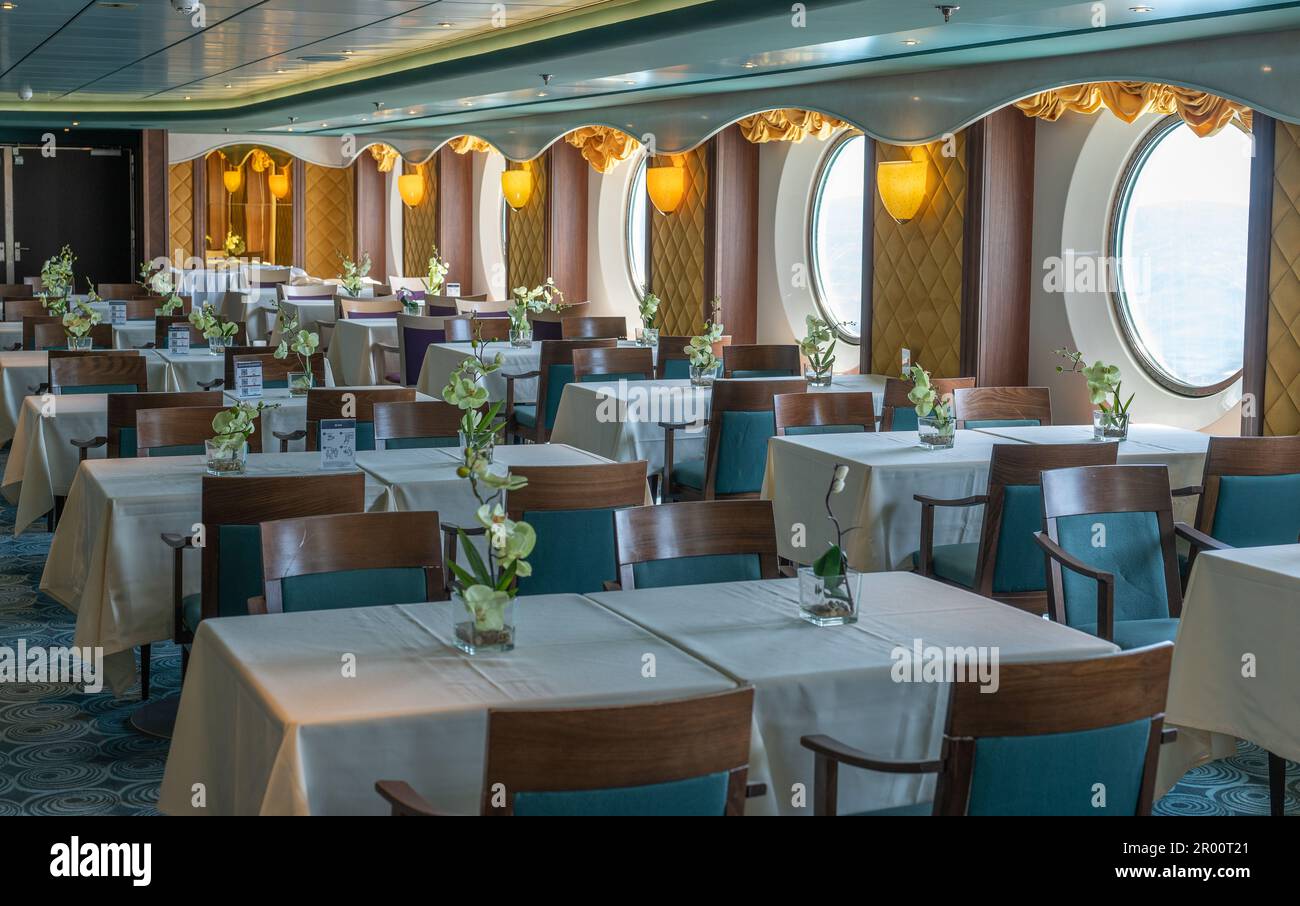 Sea cruises. interior of restaurant on sea liner. meals on cruises. internal public areas on board cruise ship. tables, portholes, decor Stock Photo