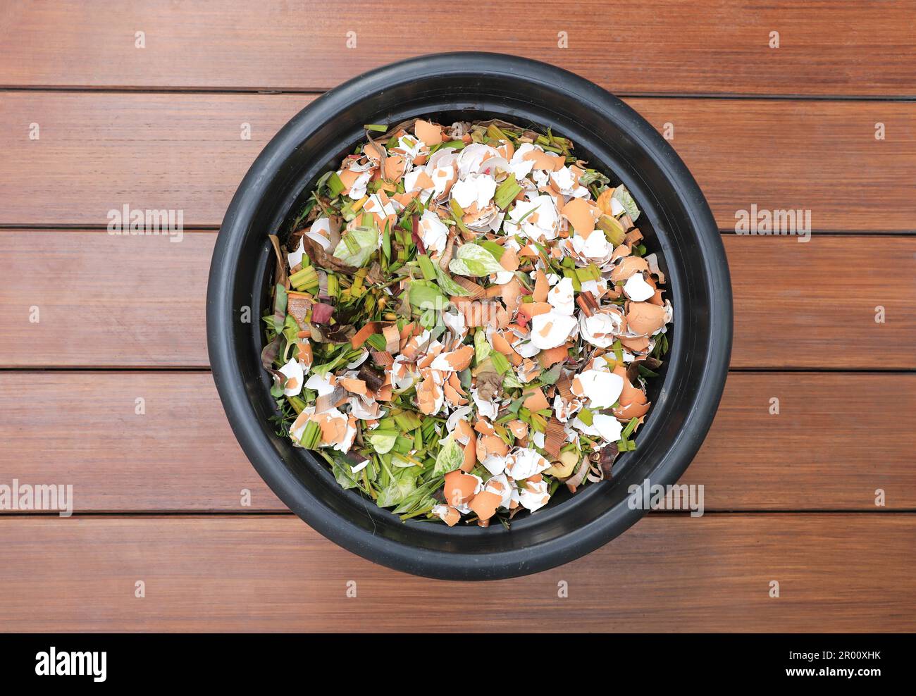 Composting pile of leaves and rotting kitchen scraps with eggshells garbage waste in black