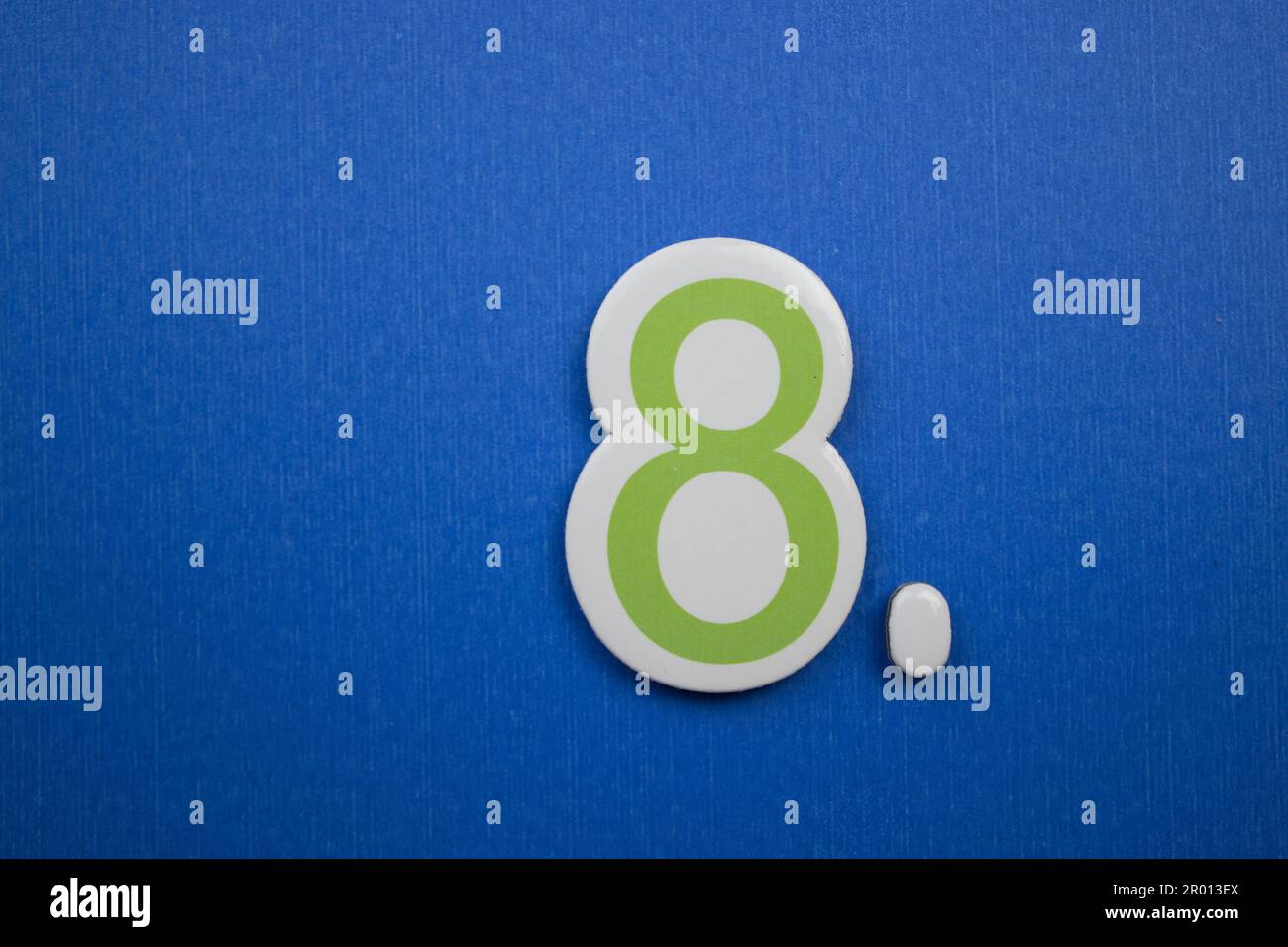The number 8, placed on a blue background, photographed from above ...