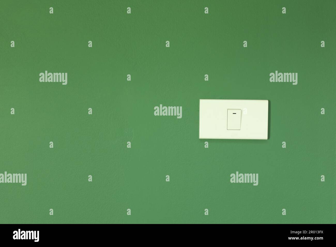 White switch installed on green wall Stock Photo