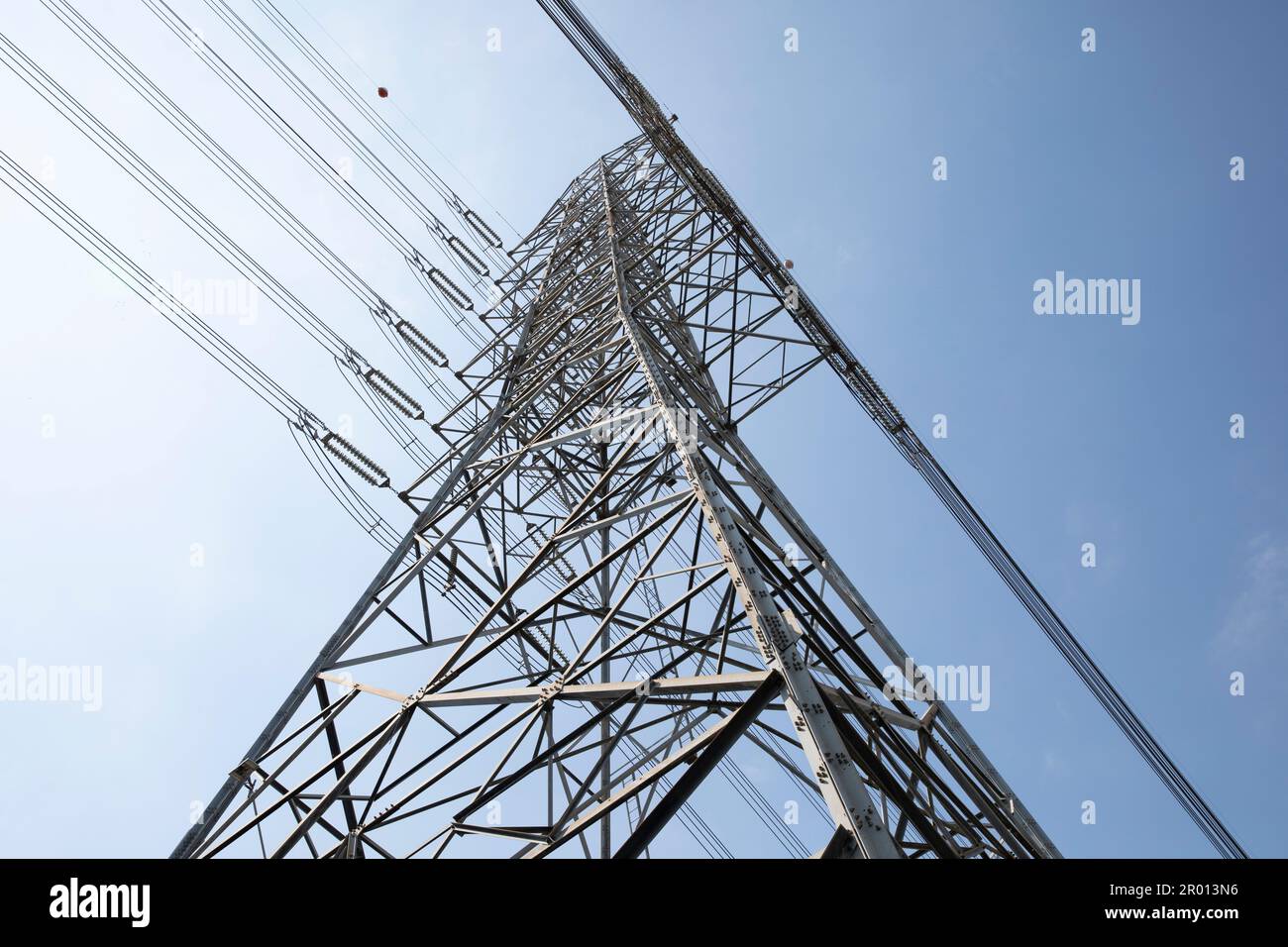 High voltage electric power lines on pylons with blue sky background. Stock Photo