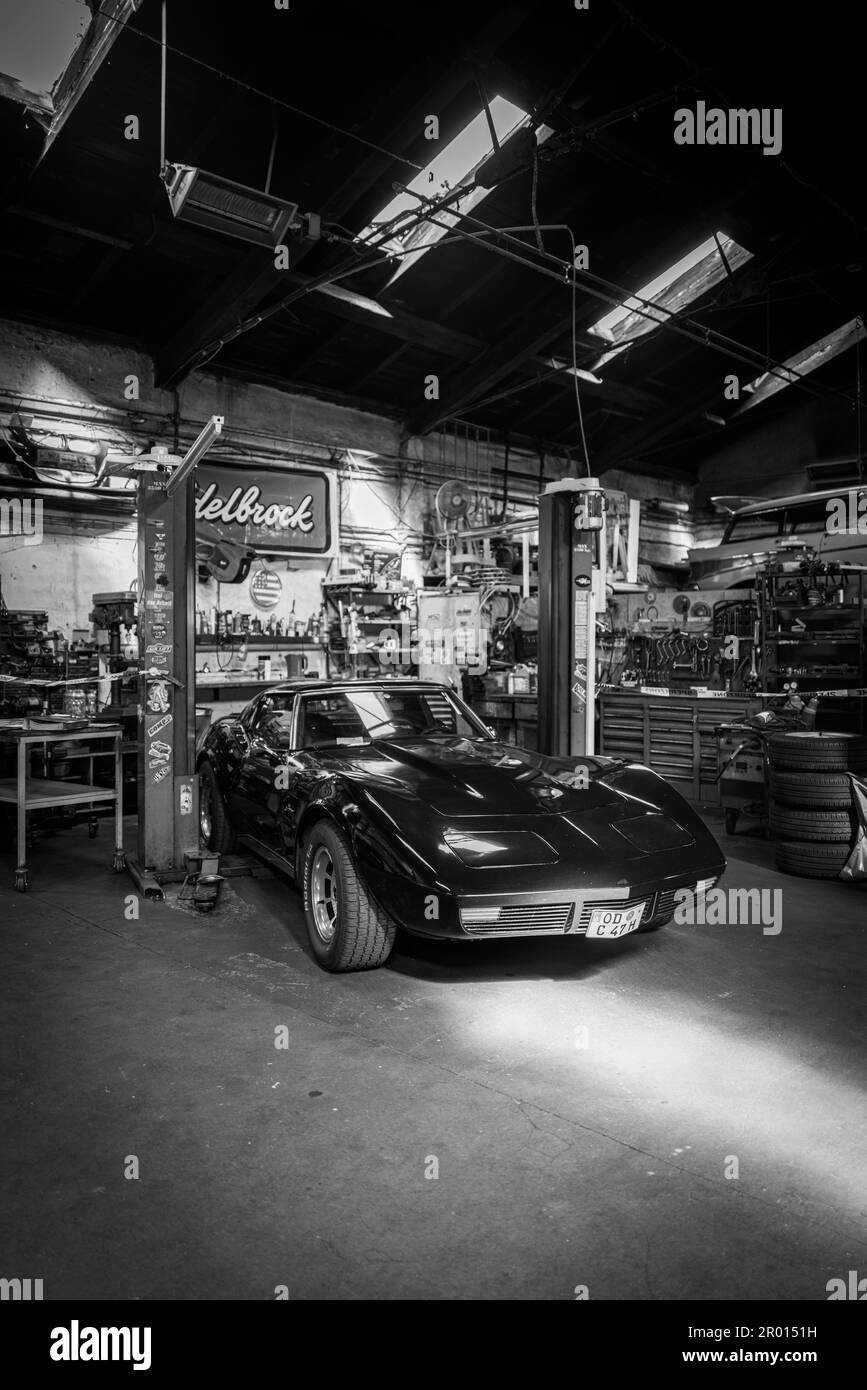 an old black Corvette C3 stands in a workshop Stock Photo