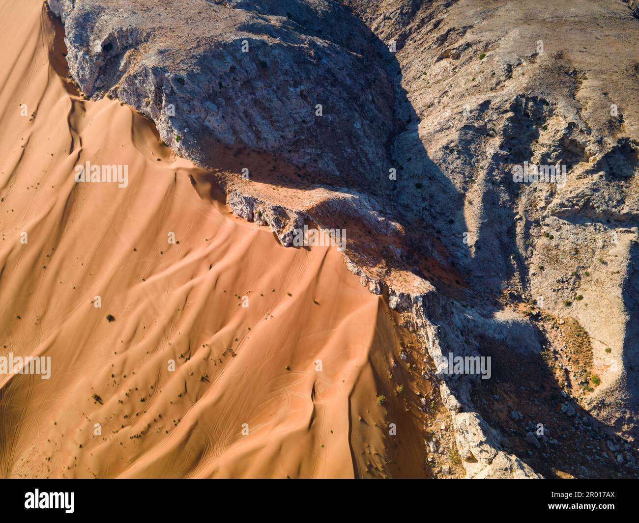 Scenic Fossil Rock in the Sharjah desert of the United Arab Emirates aerial view. Sand meeting the rocky mountain in the UAE desert Stock Photo
