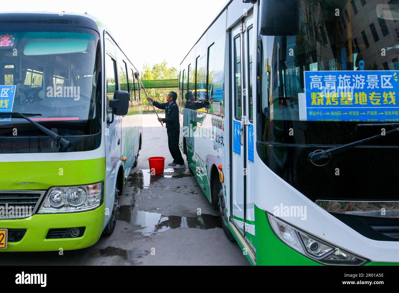 Zibo, China's Shandong Province. 29th Apr, 2023. A driver cleans a bus dedicated to a budget-friendly transport service offered to barbecue diners in Gaoqing County of Zibo, east China's Shandong Province, April 29, 2023. Credit: Zhang Weitang/Xinhua/Alamy Live News Stock Photo
