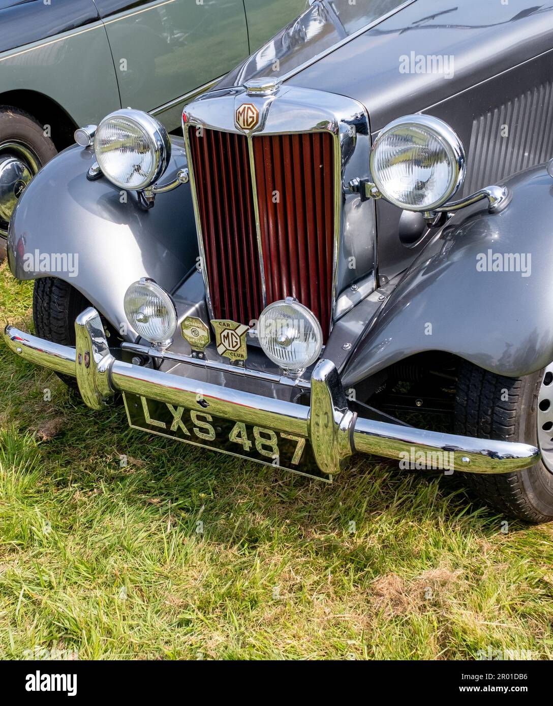 Earsham, Norfolk, UK – April 30 2023. Close up of the headlights, grille, bumper and bonnet of a fully restored classic MG car on display at a small a Stock Photo