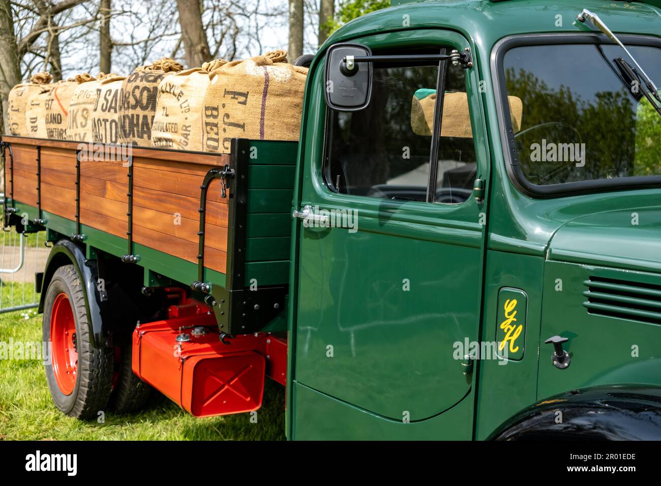 Earsham, Norfolk, UK – April 30 2023.  A restored classic delivery truck loaded up with sacks of product on display at a small and local outdoor car s Stock Photo