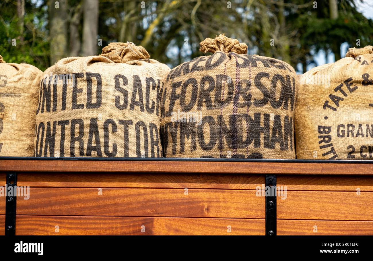 Earsham, Norfolk, UK – April 30 2023. Hessian sacks of product loaded on the wooden trailer of a classic Bedford delivery truck Stock Photo