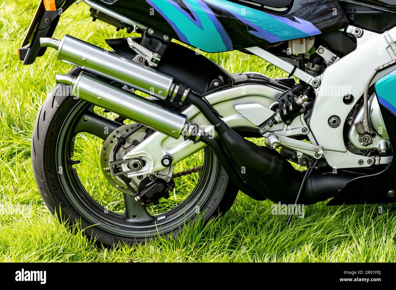 Earsham, Norfolk, UK – April 30 2023. The rear wheel, tyre and twin exhaust system of a Suzuki RGV250 2 stroke race replica sports motorbike Stock Photo
