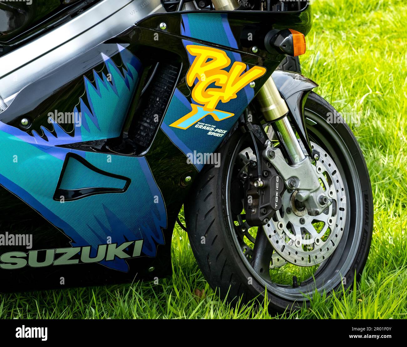 Earsham, Norfolk, UK – April 30 2023.  The front wheel, tire and fairing of a classic Suzuki RGV250 2 stroke race replica sports motorcycle Stock Photo