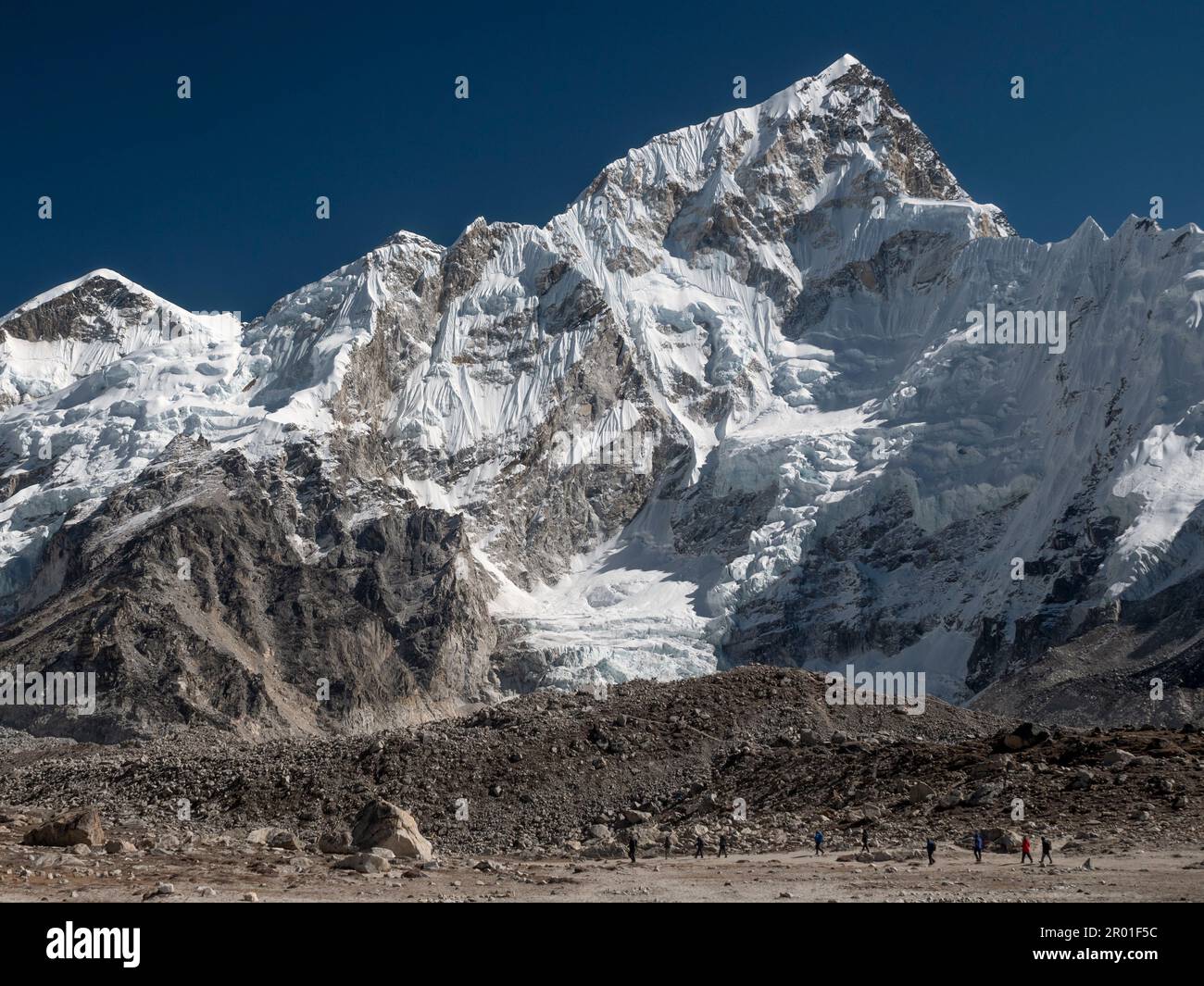 Nepal, Trekkers going to Everest Base camp with 7861meters Nuptse mountain in the background. Stock Photo