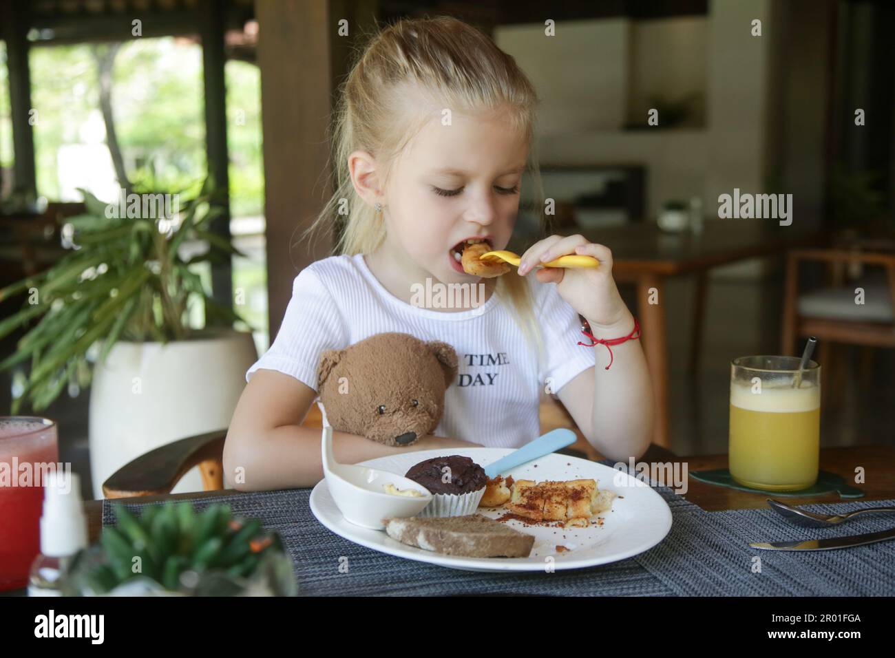 Cute 5 years old girl having kids meal at the restaurant Cute 5 years old girl having kids meal at the restaurant Stock Photo