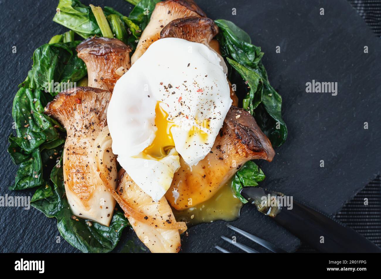 Grilled Pleurotus eryngii mushrooms with poached egg and spinach. Hot
